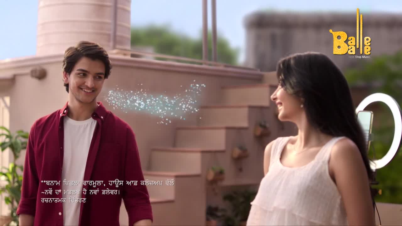 A young man smiles, and a sparkling effect emanates from his mouth toward a woman with a ring light. The Balle Balle logo sits in the top right corner.

