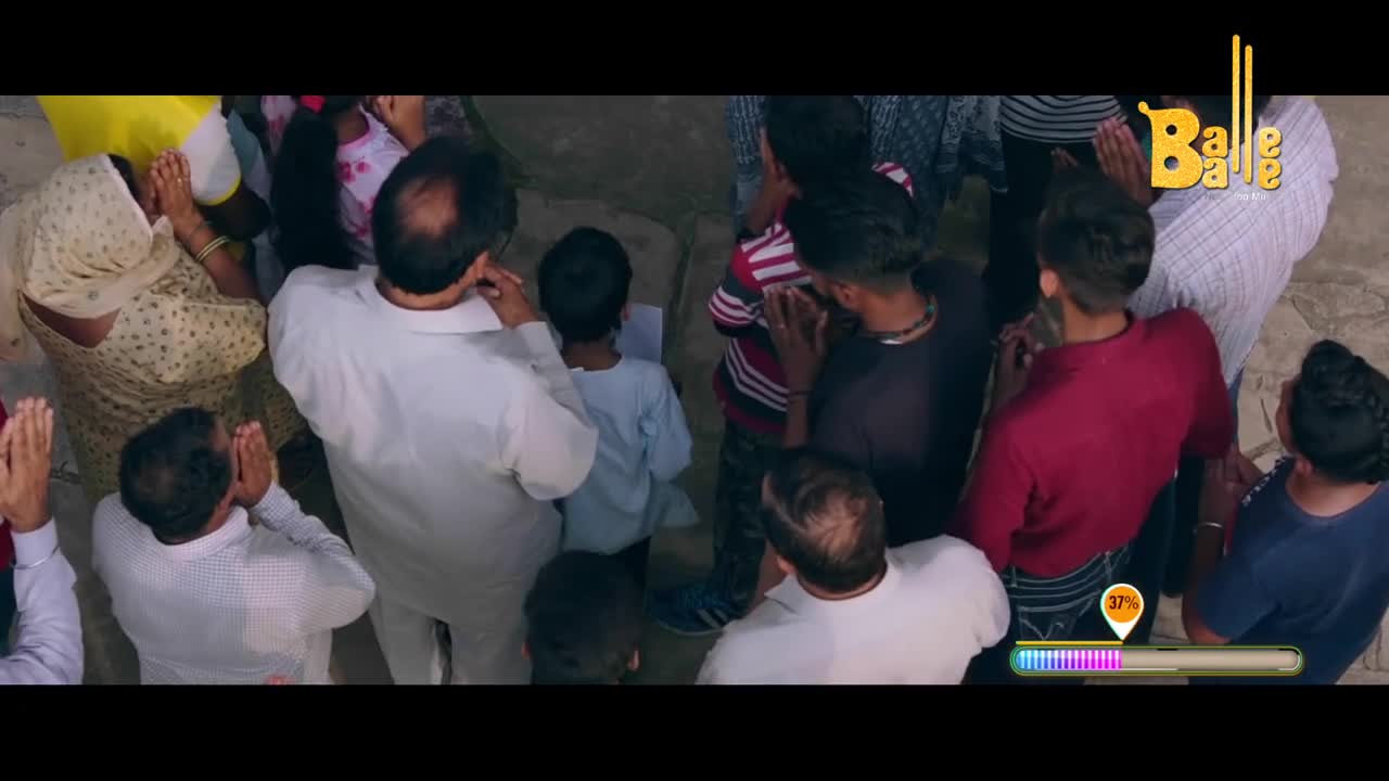 A crowd of people, many with their hands pressed together, seems to be watching something. The "Balle Balle" logo sits in the corner, and a progress bar is visible.
