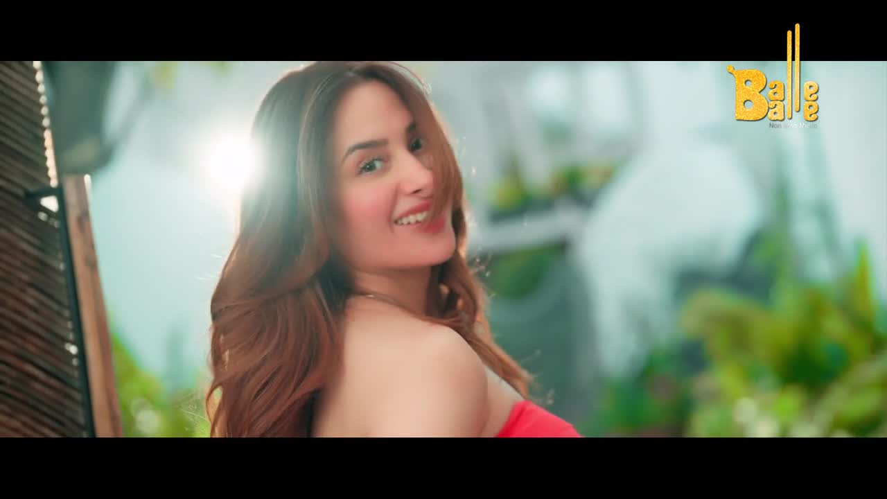 A woman with long, auburn hair turns her head, a bright smile on her face. The Balle Balle logo is visible in the upper right corner.