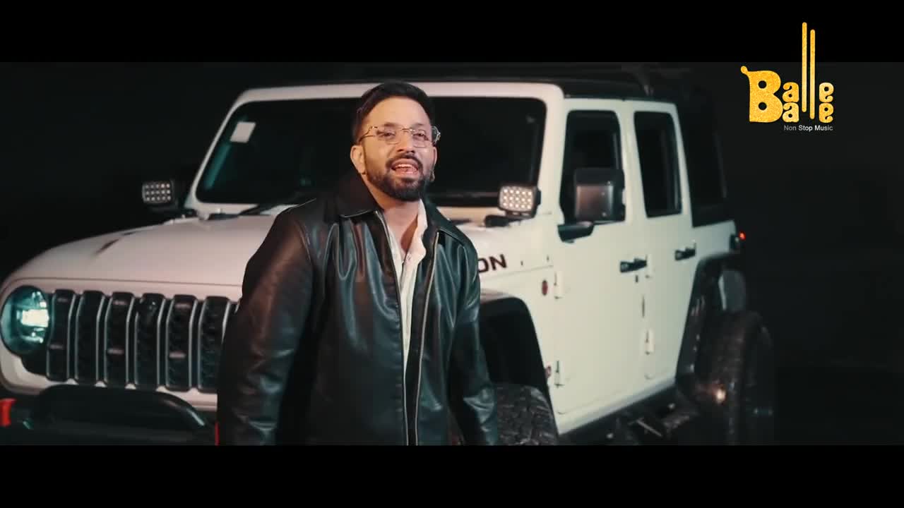 A man in a leather jacket stands before a white Jeep, his mouth open as if singing. The Balle Balle logo, bright yellow against the dark background, suggests this is part of a Punjabi music video.