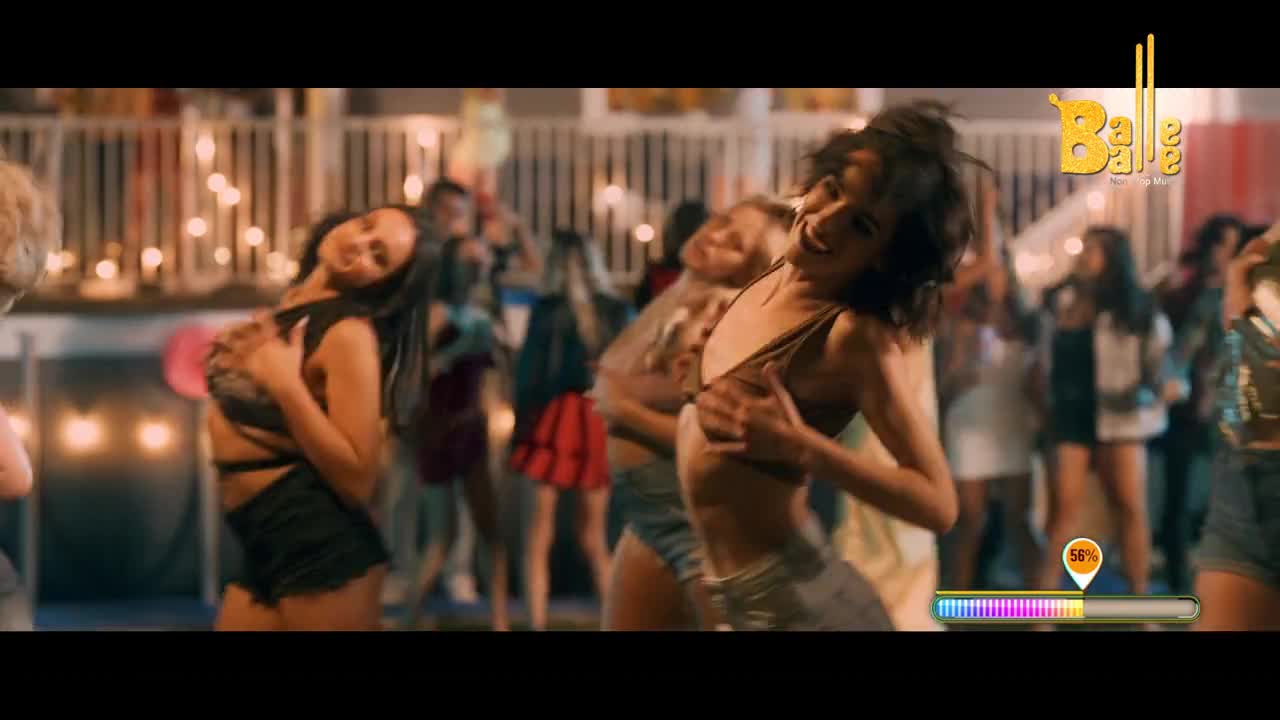 A group of women are dancing with energy, their movements fluid and expressive. The air buzzes with a festive spirit, hinting at a lively celebration.