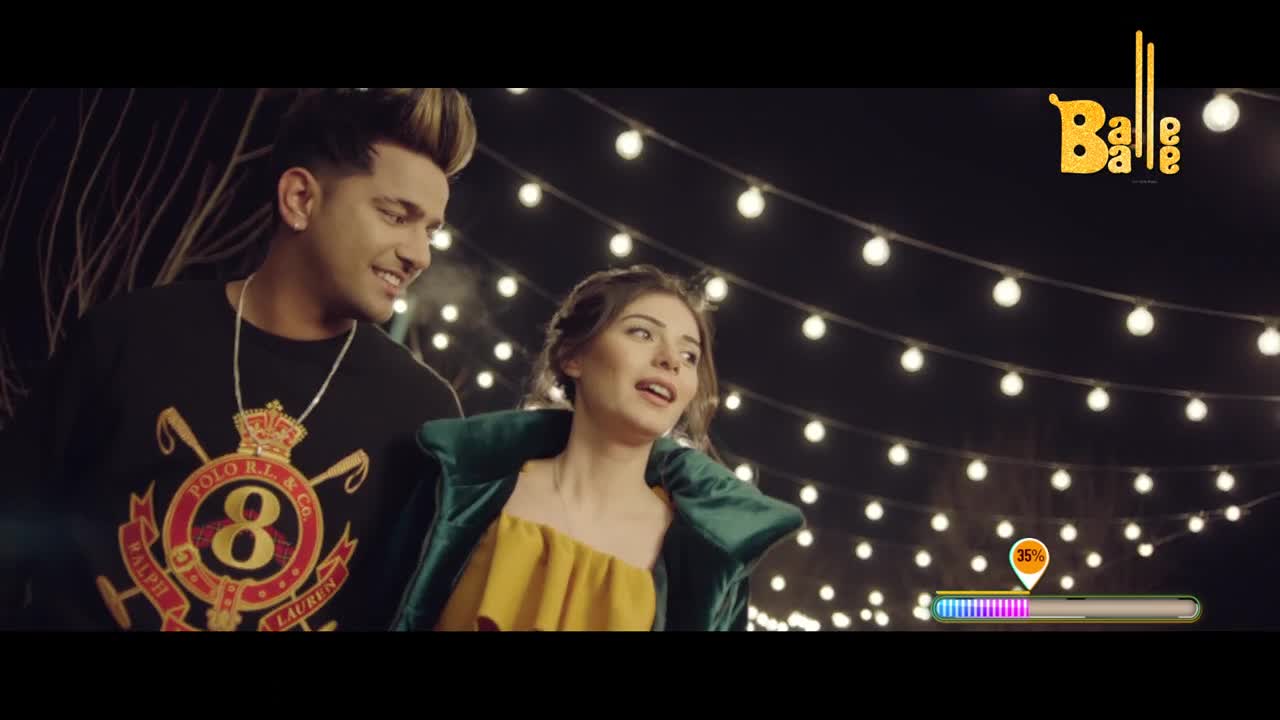 A young man with a striking hairstyle grins, his Polo Ralph Lauren shirt visible. Beside him, a woman in a yellow top and green jacket looks off to the side, her expression lively. Strings of festive lights hang overhead, illuminating the night.