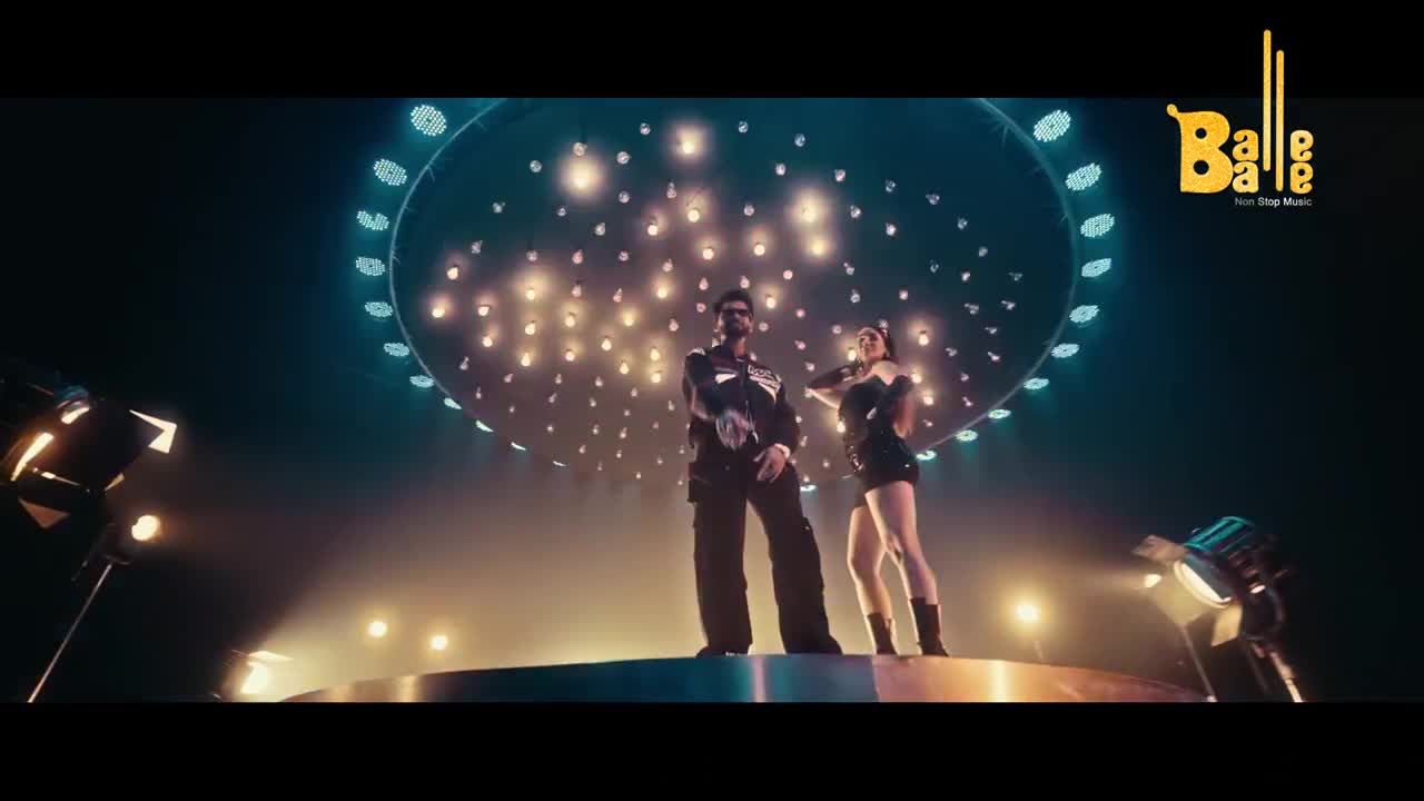 A man and a woman stand on a circular stage under a dome of lights. The Balle Balle logo is visible in the upper right corner.