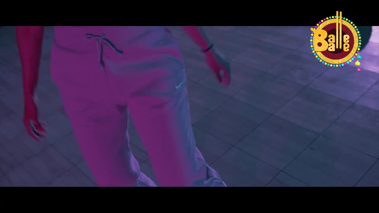 A person in light-colored track pants moves across a tiled floor, bathed in purple light. The "Balle Balle" logo hovers in the upper right corner.