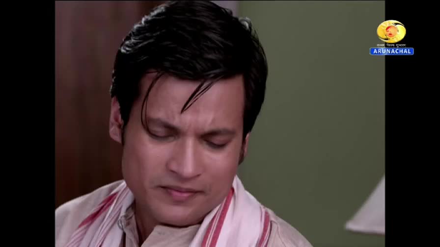 The man's eyes are downcast, his expression a mix of concern and pensiveness. A DD Arun Prabha logo is visible in the corner, suggesting this is a scene from Indian television.
