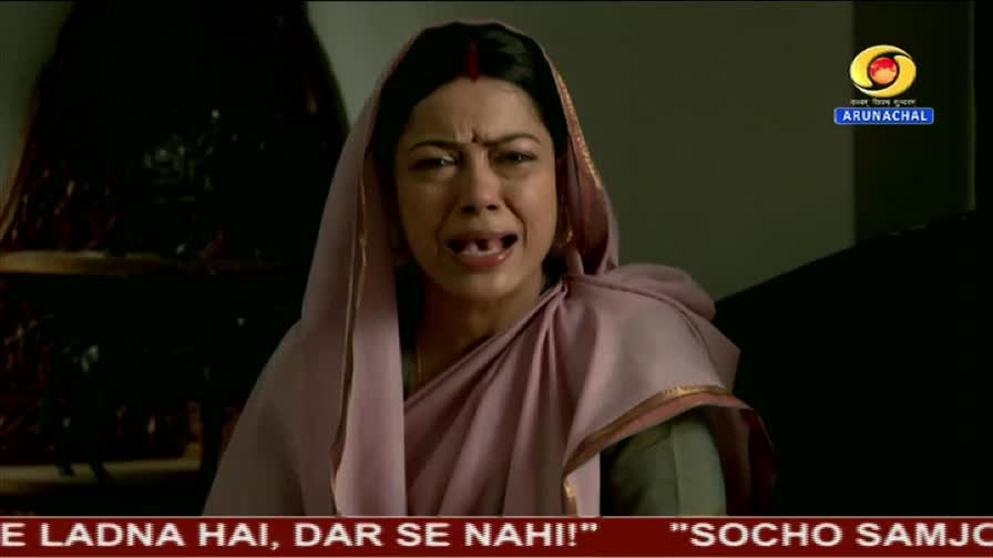 A woman, wearing a pink sari and a head covering, is crying, her mouth open in a wail. The DD Arun Prabha logo is visible in the corner of the screen.
