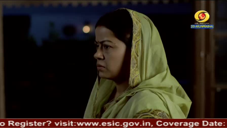 A woman in a light green headscarf stares off to the side, her expression serious. The DD Arun Prabha logo is visible in the corner, and a website address scrolls beneath the frame.
