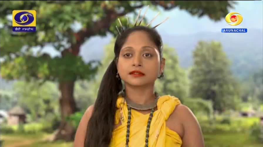 A young woman stands in traditional attire, her gaze steady. The DD Arun Prabha logo is visible in the corner, suggesting this is a broadcast from Arunachal.