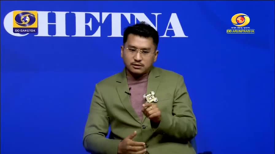 A man in a green blazer speaks animatedly, his hands gesturing. The backdrop features the DD Arun Prabha logo and the word "CHETNA."