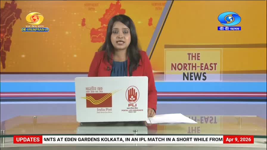A woman in a red jacket is speaking, with "THE NORTH-EAST NEWS" displayed behind her. A laptop in front of her shows the logos for India Post and Postal Life Insurance.