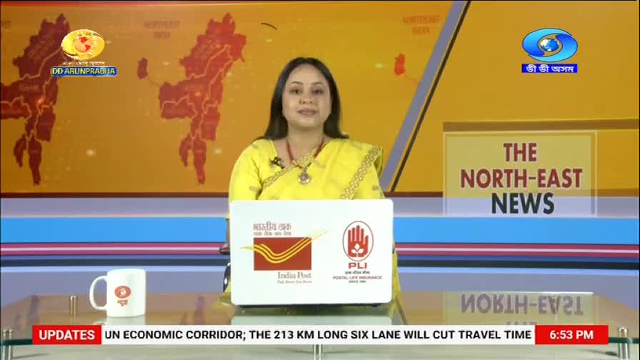 A woman in a bright yellow sari is speaking, her voice clear and steady. Behind her, a map of Northeast India fills the screen, with the DD Arun Prabha logo in the corner.