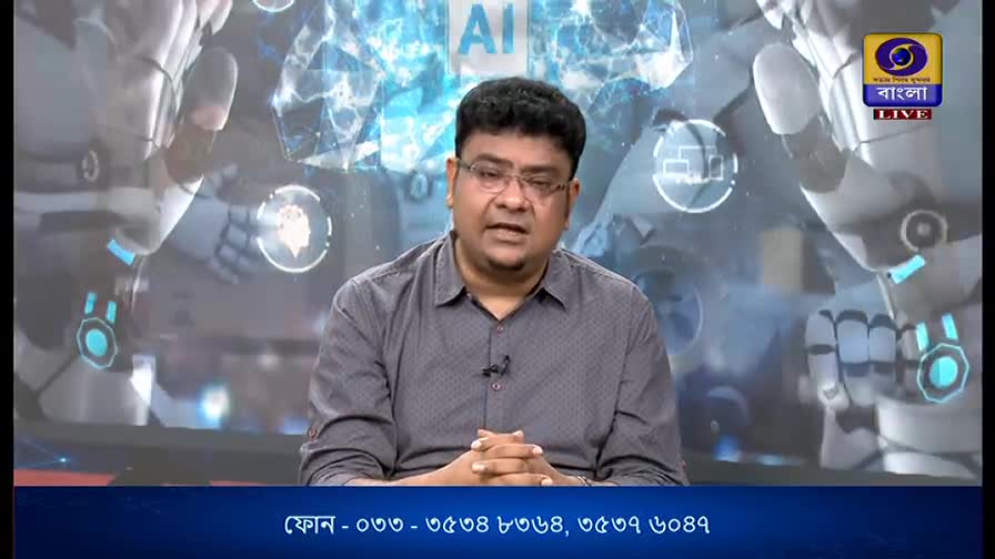 A man in glasses, speaking earnestly, is centered on the DD Bangla screen, with a backdrop of robotic imagery. The channel's logo and phone number are visible at the top and bottom of the frame.
