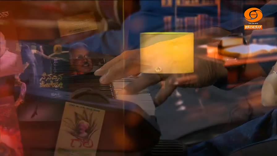 Fingers dance across the keys of a harmonium, the instrument's dark wood and metal glinting in the light. A man's face, partially visible, seems to be singing along to the music.
Fingers dance across the keys of a harmonium, the instrument's dark wood and metal glinting in the light. A man's face, partially visible, seems to be singing along to the music.