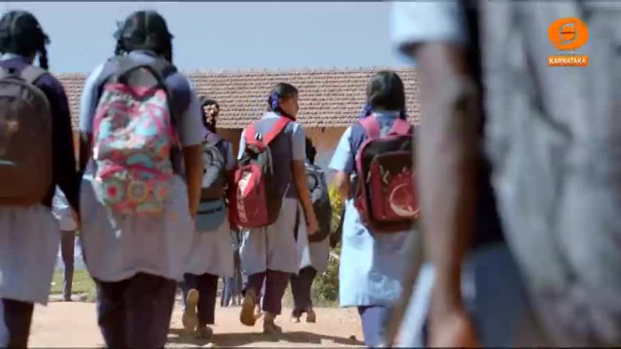 Girls in school uniforms walk away, their backpacks a mix of bright colors and muted tones. The DD Chandana logo is visible in the corner, suggesting this is a scene from Karnataka.