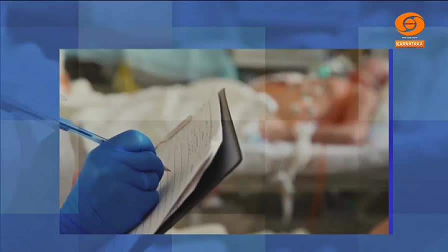 A gloved hand grips a pen, meticulously filling out a chart. Behind, a patient lies in a hospital bed, surrounded by medical equipment.