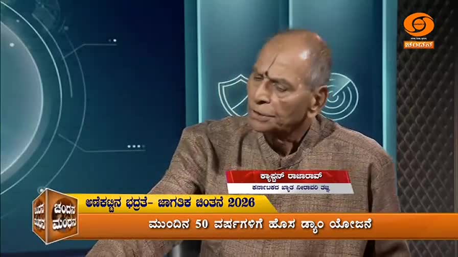 An older man with a tilak on his forehead speaks animatedly, his hands gesturing. The DD Chandana logo is visible in the corner, and a graphic displays text in Kannada.