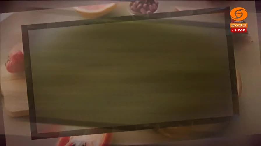 A red tomato and a sliced grapefruit sit on a wooden board. The DD Chandana logo and "LIVE" flash in the corner of the screen.