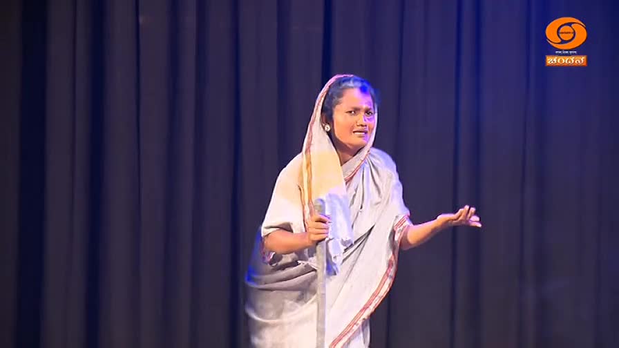 A woman in a traditional sari grips a walking stick, her face animated as she speaks. The DD Chandana logo is visible in the corner, suggesting a broadcast from India.