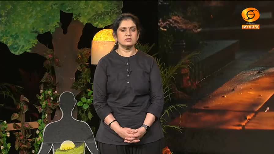 A woman in a black kurta stands before a backdrop of trees and a stylized human silhouette. The DD Chandana logo is visible in the upper right corner.