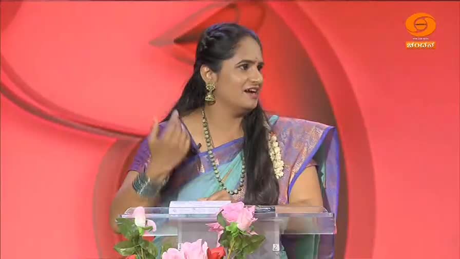 A woman in a bright blue and purple sari gestures animatedly while speaking. The DD Chandana logo appears in the corner of the screen.