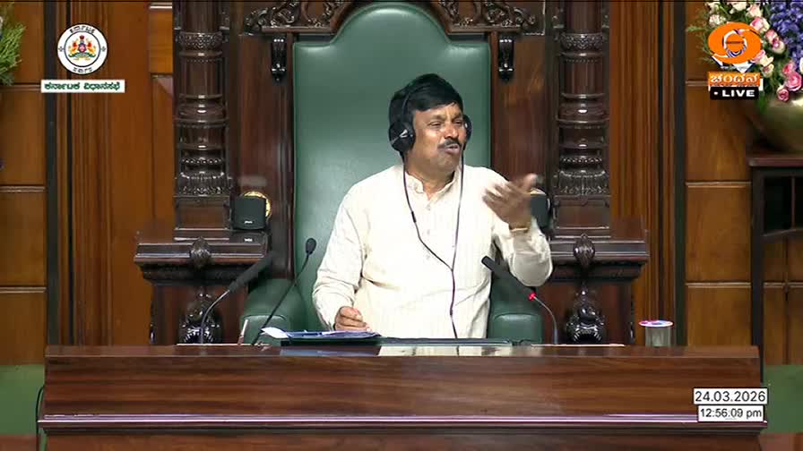 A man in a light-colored kurta speaks animatedly from a large, ornate chair, his hand gesturing as if making a point. The DD Chandana logo is visible in the corner, indicating this is a broadcast from Karnataka.