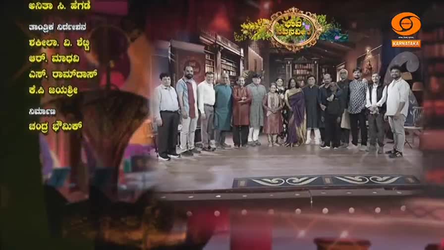 A group of people stands together on a polished floor in front of a bookshelf-lined wall. A logo for DD Chandana Karnataka hovers above them.