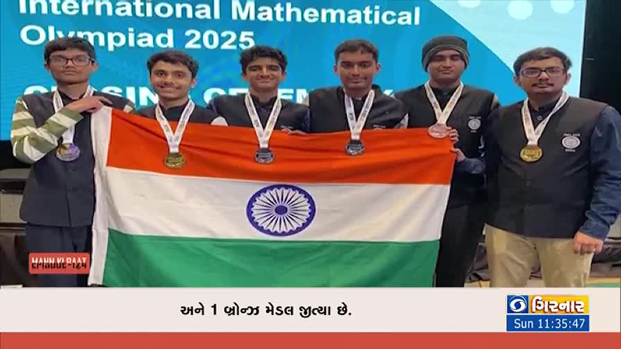 Six men, each wearing a medal, hold up the Indian flag. The DD Girnar logo is visible in the corner, marking this as a broadcast about the International Mathematical Olympiad.
