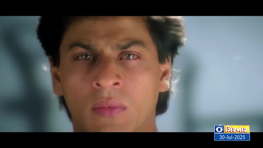 The man's gaze is steady, his features etched with a serious expression. A DD Girnar logo and date are visible in the corner of the screen.
