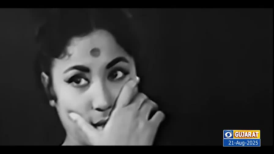 A woman, adorned with a bindi, rests her chin on her hand, her eyes fixed on something beyond the frame. The DD Girnar logo in the corner gives the context of a broadcast from Gujarat.
