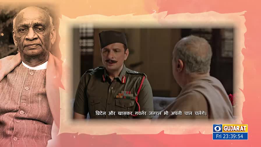 A man in a military uniform, with a dark cap and a thick mustache, is speaking to another man. The broadcast is on DD Girnar, with a portrait of Sardar Vallabhbhai Patel in the background.

