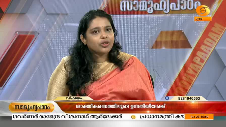 A woman in a gold blouse and coral sari speaks directly to the camera, her expression earnest. The DD Malayalam logo and program title are visible on the screen behind her.
