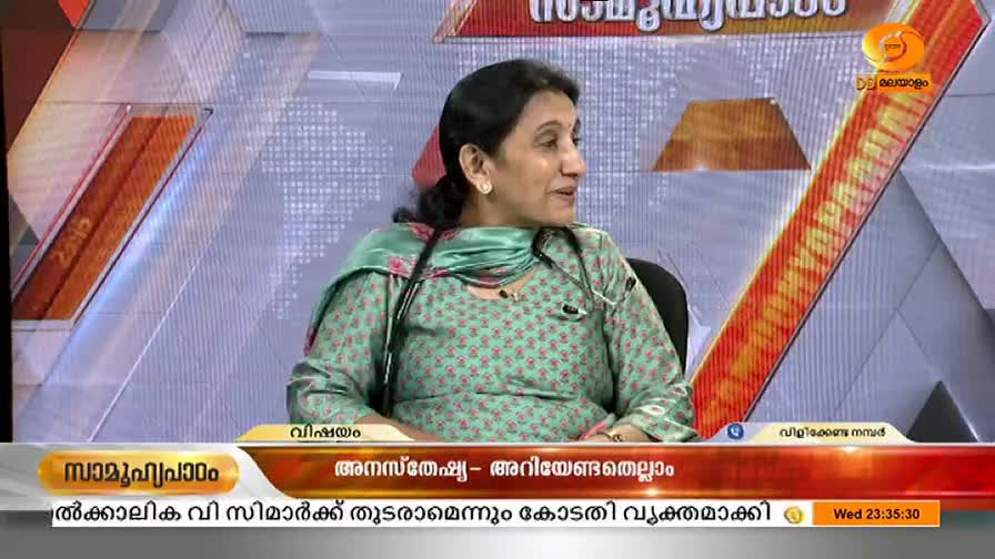 A woman in a floral print top and a stethoscope around her neck is speaking on a DD Malayalam program. The show's title, "Anesthesia - All You Need to Know," is displayed on the screen.
