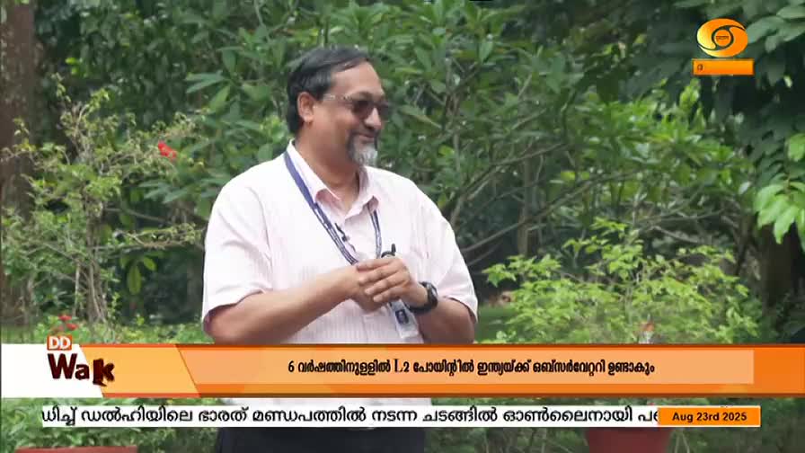 A man in a light-colored shirt stands in front of some greenery, likely for a DD Malayalam broadcast. The lower third of the screen displays text about India and an observatory, with the date August 23rd, 2025.
