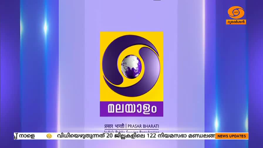 The DD Malayalam logo, a yellow circle with a purple ring and a globe, dominates the screen. Below, the word "Malayalam" is written in purple, with news updates scrolling at the bottom.
