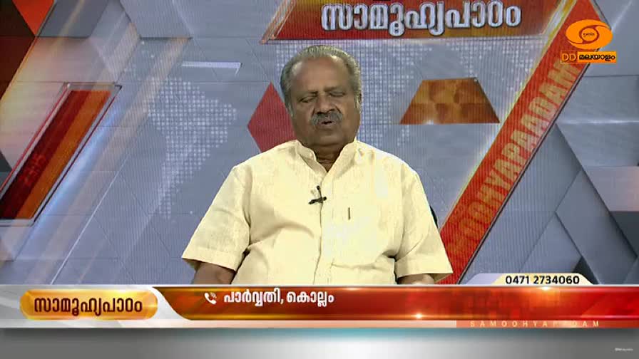 A man in a light yellow shirt speaks earnestly, his mouth moving as he addresses the camera. The DD Malayalam logo and a graphic with Malayalam text are visible in the background.
A man in a light yellow shirt speaks earnestly, his mouth moving as he addresses the camera. The DD Malayalam logo and a graphic with Malayalam text are visible in the background.