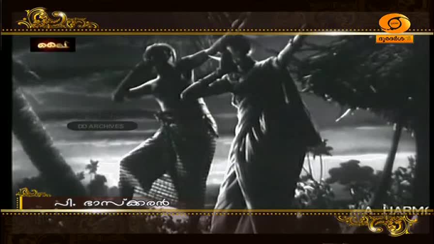 Two figures move with dramatic gestures, their arms raised and bodies twisted. The scene, broadcast on DD Malayalam, unfolds against a backdrop of dark, silhouetted trees.