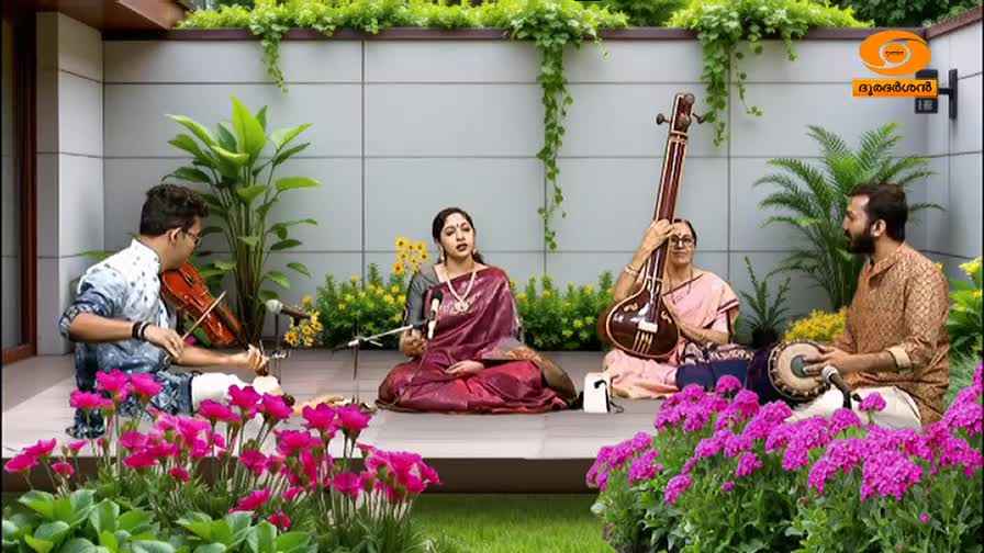 A violinist plays with his bow gliding across the strings, while a singer in a maroon saree holds a microphone. To their right, a woman cradles a tanpura, and a man taps a rhythm on a mridangam.