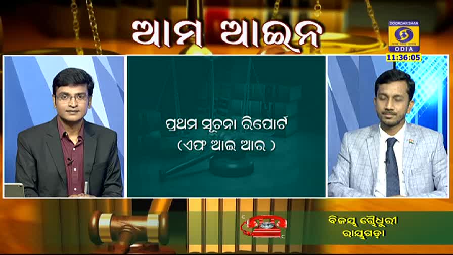 Two men in suits are seated on a television set, likely for a DD Odia program in India. A title card with text in Odia is displayed between them, and a gavel and a red telephone are at the bottom of the screen.
