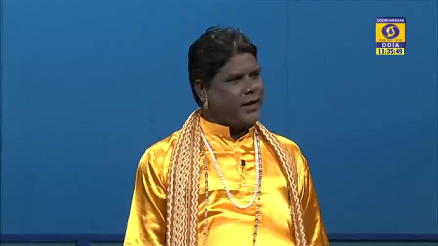 A man in a bright yellow outfit is speaking, his expression animated. The DD Odia logo and a time stamp appear in the corner of the screen.
