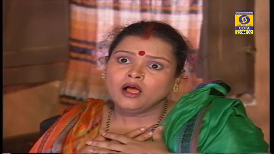 The woman's eyes are wide, and her mouth is open, as if she's just been surprised. A DD Odia logo in the corner indicates this is a scene from Indian television.
