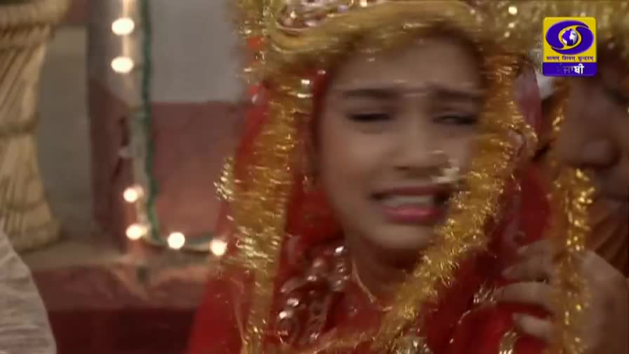 A young woman, adorned in red and gold, is weeping, her face contorted with emotion. The DD Punjabi logo in the corner indicates a scene from a television drama playing out before me.

