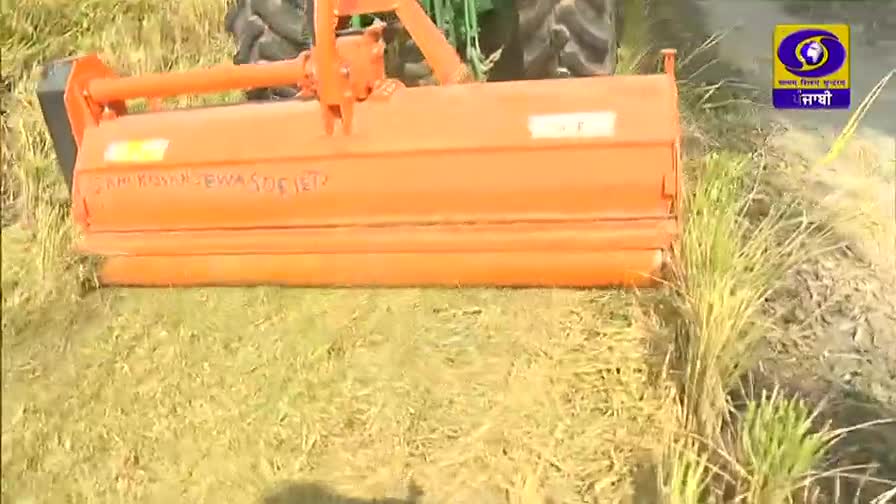 An orange machine attached to a tractor is cutting through the tall, golden crops. The scene is likely being broadcast on DD Punjabi, a channel from India.
