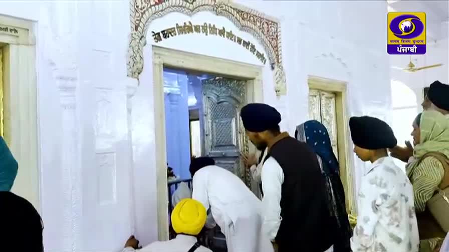 People are gathered at the entrance of a building, some looking inside. A DD Punjabi logo is visible in the corner.
