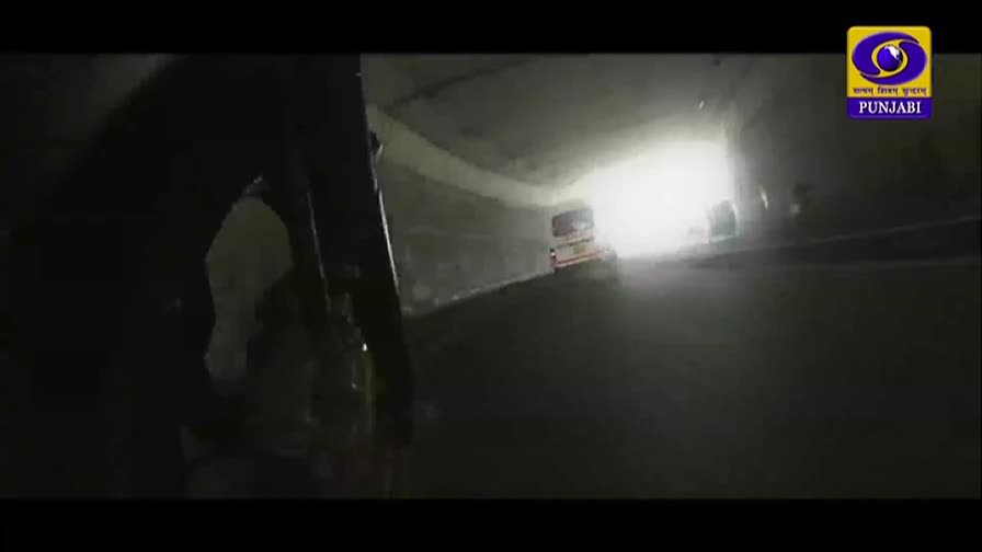 A white van with red stripes moves through a dimly lit tunnel. The DD Punjabi logo is visible in the upper right corner.