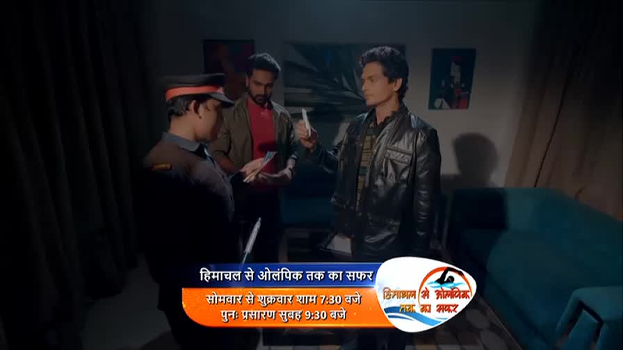 A man in a black leather jacket holds up a piece of paper, speaking to a uniformed officer and another man. The scene is lit by a dim lamp, casting long shadows.
