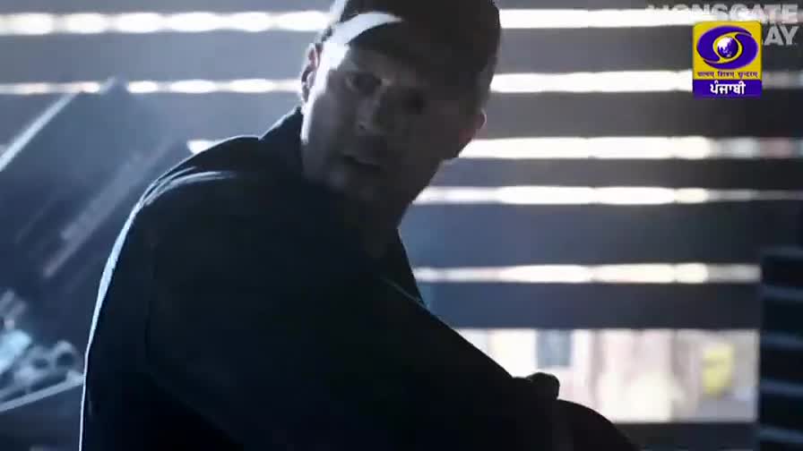 A man in a dark jacket and baseball cap turns his head, his expression tense. The DD Punjabi logo is visible in the corner, suggesting this is a broadcast from India.