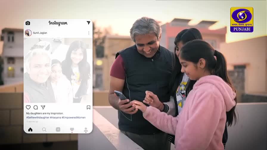 A father and his two daughters huddle around a phone, sharing a moment on a rooftop. The screen displays an Instagram post with a photo of the family and the caption "My daughters are my Inspiration."