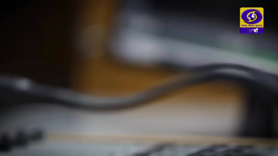 A dark, curved cable snakes across the frame, its surface catching a faint light. Above it, the logo for DD Punjabi, a television channel from India, is visible in the corner.