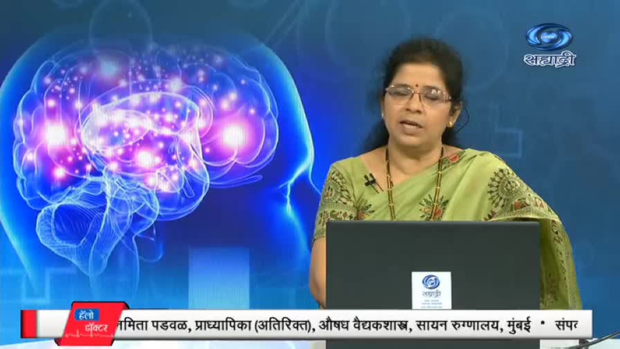 A woman in a green sari speaks earnestly from behind a laptop, against a backdrop of a glowing brain illustration. The DD Sahyadri logo is visible on the screen and in the corner.
