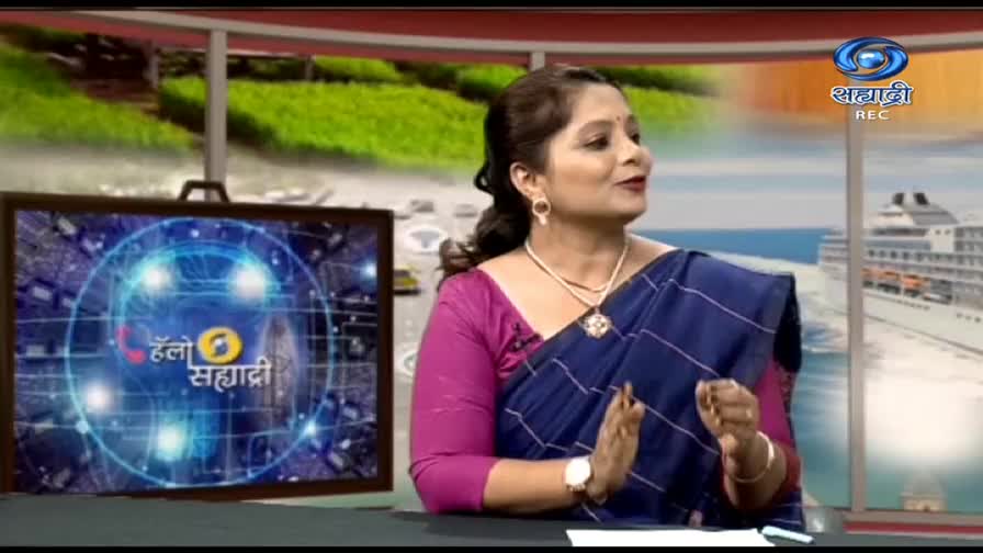 The woman in a blue saree gestures while speaking, her hands moving in front of her. Behind her, the DD Sahyadri logo and a graphic screen are visible, with a cruise ship in the background.
